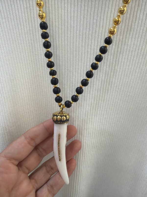 Collar Largo de Madera Negra y Dorada con Colgante Colmillo Blanco